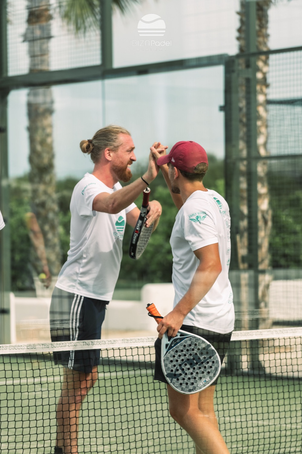 A coach on a sunlit padel court in Ibiza