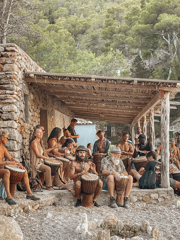A beach drum circle under a rustic shelter in Ibiza