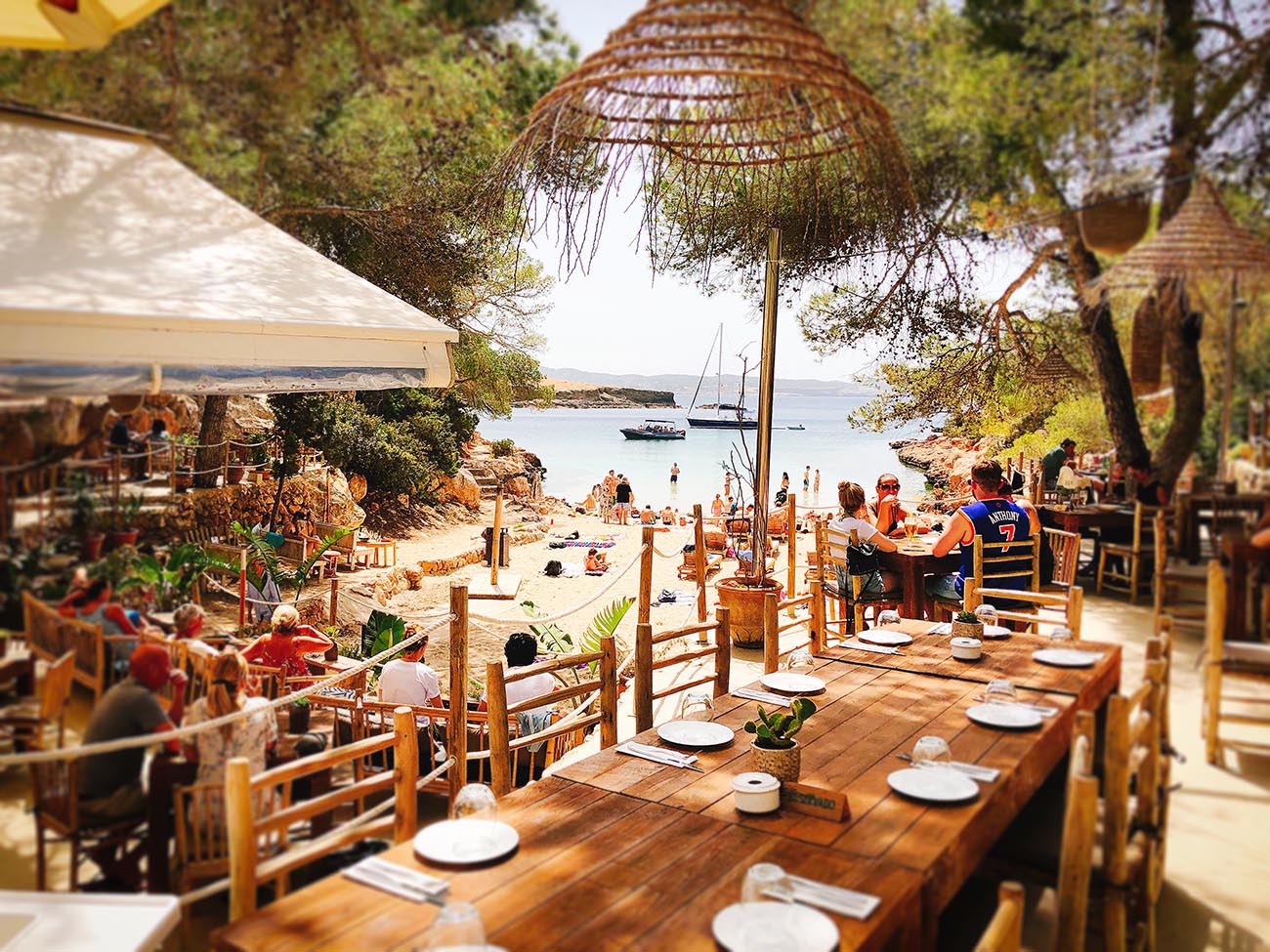 A long table at a beachside restaurant on an Ibiza cove